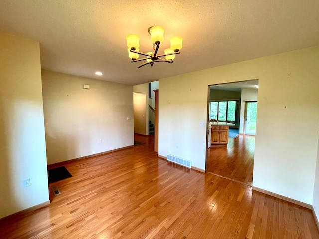 416 Rako St SW, Bemidji, MN 56601 - spare room with a chandelier, light wood-type flooring, baseboards, stairway, and recessed lighting