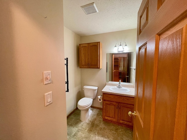 416 Rako St SW, Bemidji, MN 56601 - bathroom with toilet, vanity, a textured ceiling, and baseboards