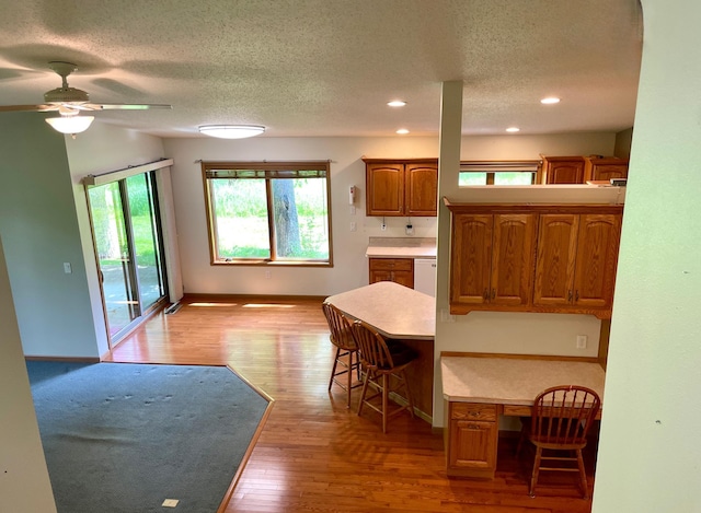 416 Rako St SW, Bemidji, MN 56601 - kitchen with brown cabinetry, light wood finished floors, a textured ceiling, recessed lighting, and a ceiling fan