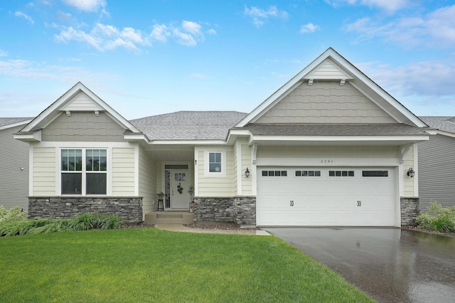 6645 91st St S, Cottage Grove, MN 55016 - craftsman house featuring stone siding, asphalt driveway, a front yard, and roof with shingles