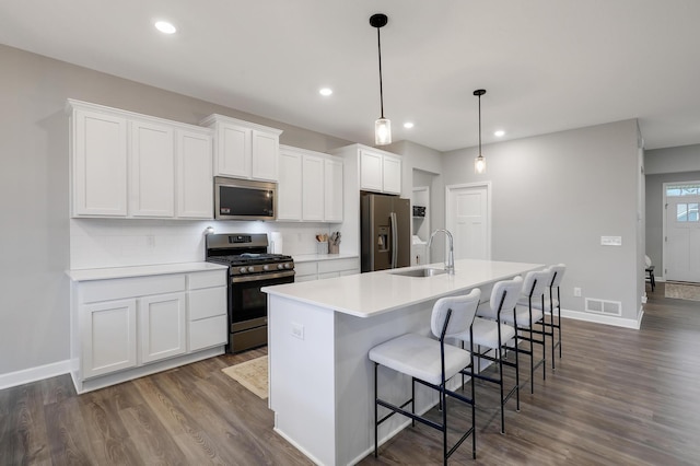 6645 91st St S, Cottage Grove, MN 55016 - kitchen with stainless steel appliances, a sink, an island with sink, white cabinetry, and dark wood-style floors