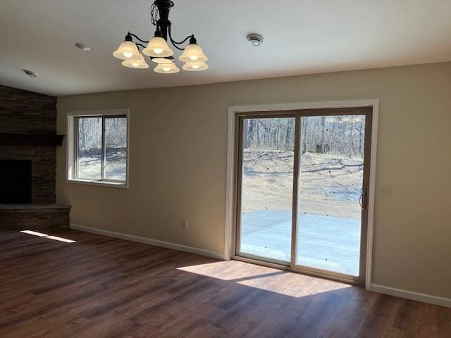 7865 Ski Chalet Dr, Breezy Point, MN 56472 - unfurnished dining area with wood finished floors, baseboards, a chandelier, a fireplace, and lofted ceiling
