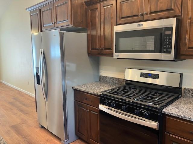 7865 Ski Chalet Dr, Breezy Point, MN 56472 - kitchen featuring stainless steel appliances, light wood-style floors, baseboards, and dark brown cabinetry