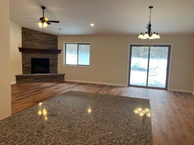 7865 Ski Chalet Dr, Breezy Point, MN 56472 - unfurnished living room with wood finished floors, ceiling fan, a chandelier, a fireplace, and baseboards