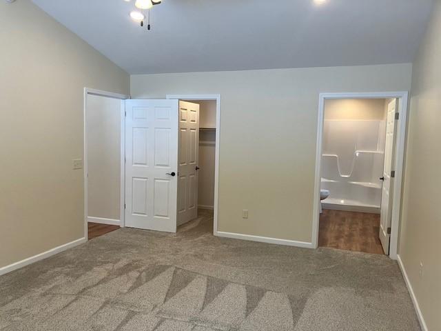 7865 Ski Chalet Dr, Breezy Point, MN 56472 - unfurnished bedroom with carpet, a spacious closet, baseboards, connected bathroom, and a closet