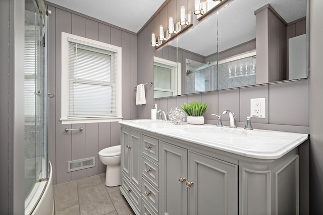 11627 Yukon St NW, Coon Rapids, MN 55433 - full bath featuring a shower with door, toilet, double vanity, and tile patterned floors