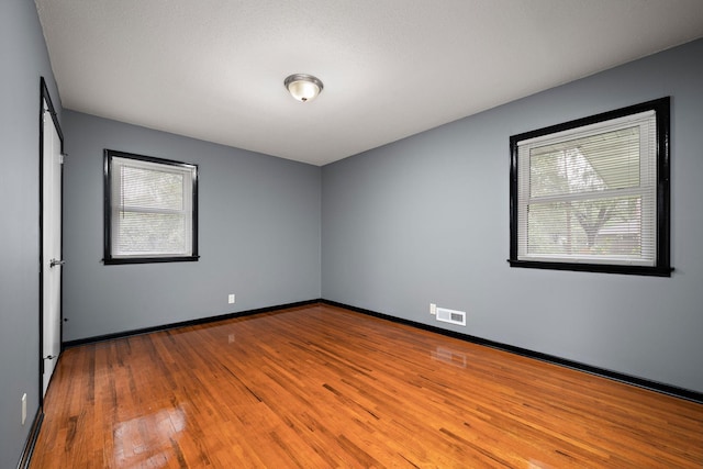 11627 Yukon St NW, Coon Rapids, MN 55433 - unfurnished room with plenty of natural light, wood finished floors, and baseboards