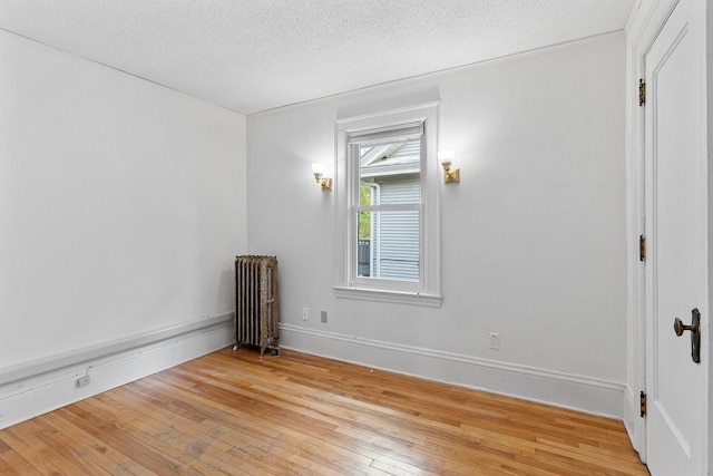 2505 Pleasant Ave, Minneapolis, MN 55404 - unfurnished room with radiator heating unit, light wood-style flooring, a textured ceiling, and baseboards