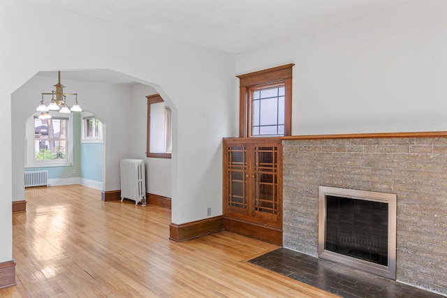 2505 Pleasant Ave, Minneapolis, MN 55404 - unfurnished living room with radiator heating unit, wood finished floors, and plenty of natural light