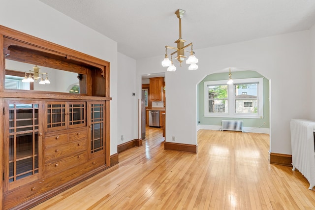 2505 Pleasant Ave, Minneapolis, MN 55404 - unfurnished dining area with a chandelier, radiator, light wood-style flooring, and arched walkways