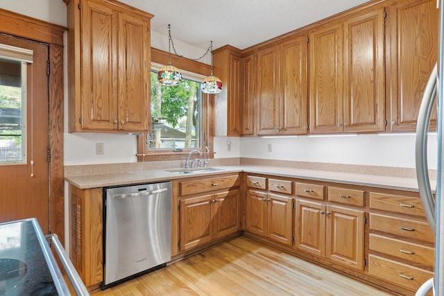 2505 Pleasant Ave, Minneapolis, MN 55404 - kitchen featuring stainless steel appliances, a sink, brown cabinets, light countertops, and plenty of natural light