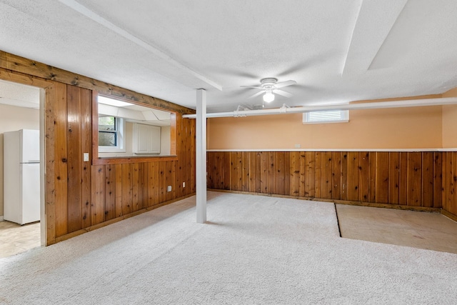 2505 Pleasant Ave, Minneapolis, MN 55404 - basement with freestanding refrigerator, wood walls, carpet flooring, a textured ceiling, and a ceiling fan