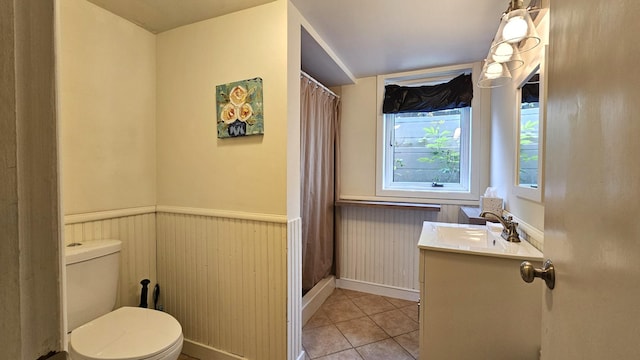 111 10th Ave SE, Elbow Lake, MN 56531 - bathroom featuring vanity, toilet, wainscoting, tile patterned flooring, and a shower with curtain