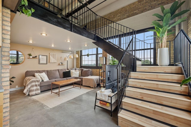 730 Stinson Blvd Unit 425, Minneapolis, MN 55413 - living room with finished concrete floors, a high ceiling, stairway, baseboards, and recessed lighting