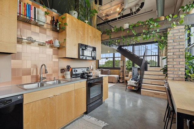 730 Stinson Blvd Unit 425, Minneapolis, MN 55413 - kitchen featuring black appliances, a sink, light brown cabinets, finished concrete floors, and decorative backsplash