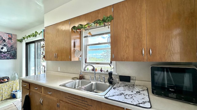 2212 Springvale Ct, Duluth, MN 55811 - kitchen with a sink, light countertops, brown cabinetry, and black microwave