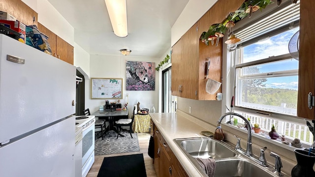 2212 Springvale Ct, Duluth, MN 55811 - kitchen featuring white appliances, a sink, light countertops, and brown cabinetry