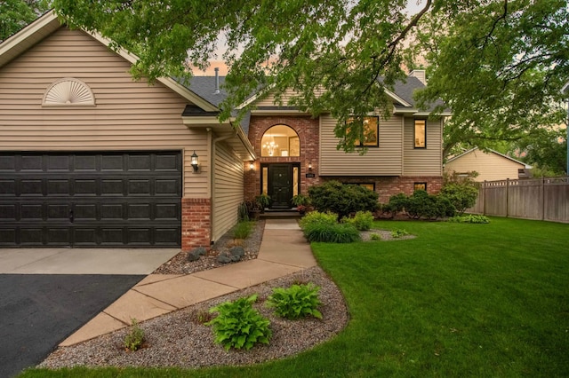 1366 140th Ln NW, Andover, MN 55304 - view of front facade with brick siding, driveway, a garage, and roof with shingles