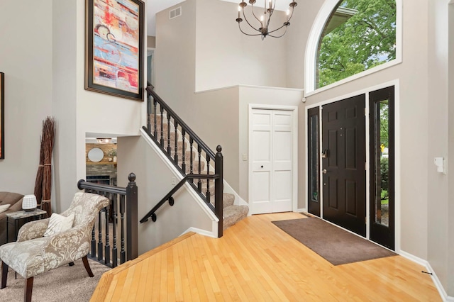 1366 140th Ln NW, Andover, MN 55304 - entrance foyer with a chandelier, wood finished floors, a high ceiling, stairs, and baseboards