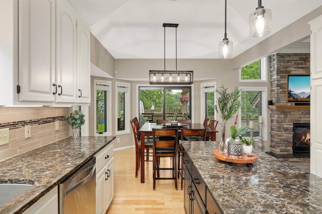 1366 140th Ln NW, Andover, MN 55304 - kitchen featuring dishwasher, light wood-style floors, backsplash, a fireplace, and white cabinets