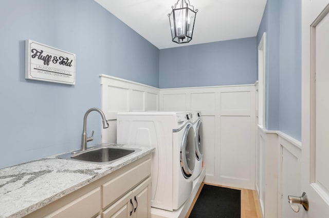 1366 140th Ln NW, Andover, MN 55304 - laundry area featuring a decorative wall, washing machine and clothes dryer, cabinet space, and wainscoting