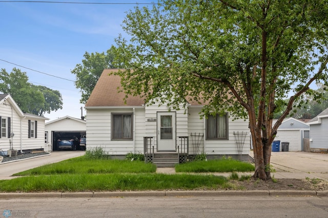 214 14th St N, Moorhead, MN 56560 - view of front of house featuring an outdoor structure, a garage, and roof with shingles