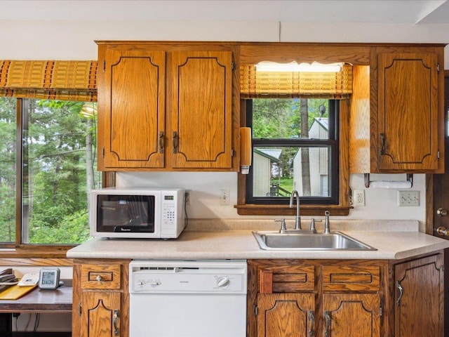 1474 Shamineau Dr, Motley, MN 56466 - kitchen featuring white appliances, light countertops, brown cabinets, and healthy amount of natural light