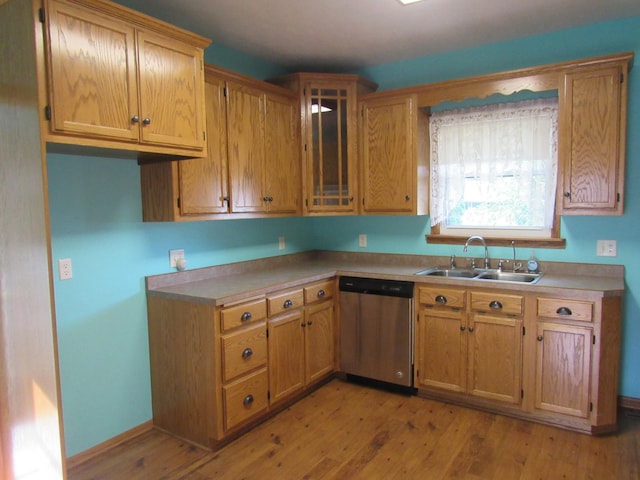 457 Rohrer St, Round Lake, MN 56167 - kitchen featuring stainless steel dishwasher, a sink, light wood finished floors, light countertops, and glass insert cabinets
