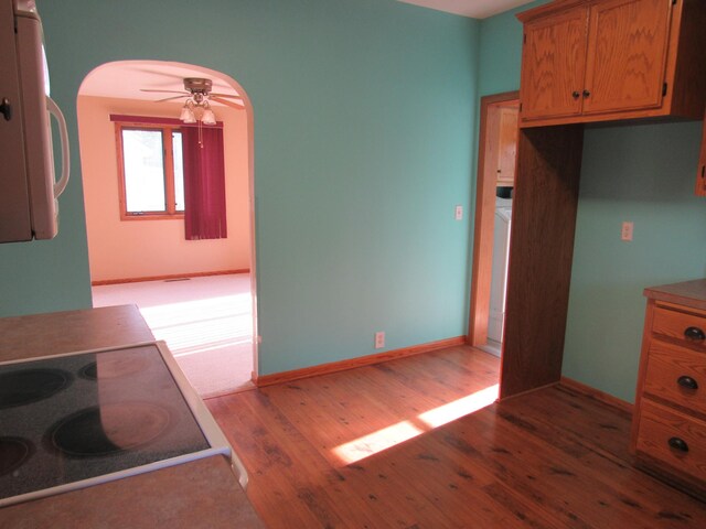 457 Rohrer St, Round Lake, MN 56167 - kitchen featuring white microwave, light wood-type flooring, arched walkways, a ceiling fan, and brown cabinets