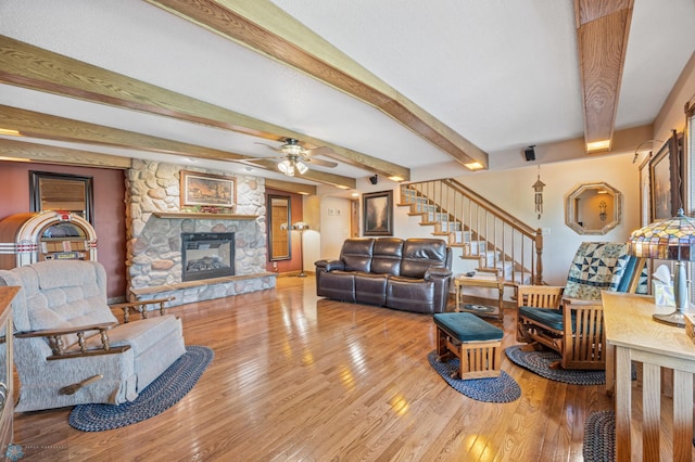 18000 10th St SW, Hawley, MN 56549 - living room with wood finished floors, beamed ceiling, a fireplace, stairs, and ceiling fan