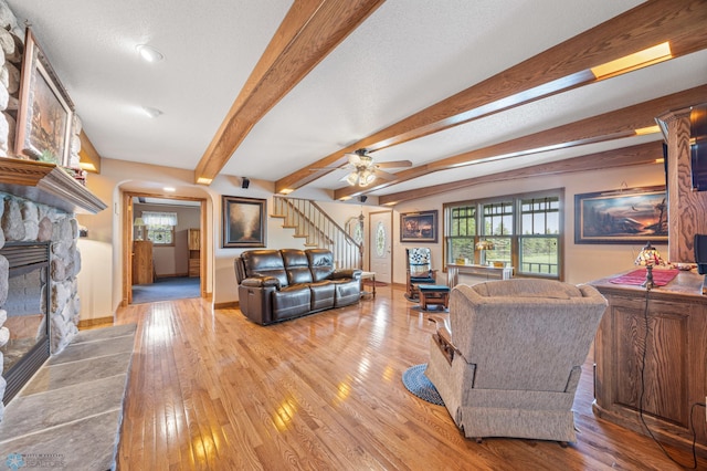 18000 10th St SW, Hawley, MN 56549 - living area with a stone fireplace, arched walkways, hardwood / wood-style flooring, stairway, and baseboards