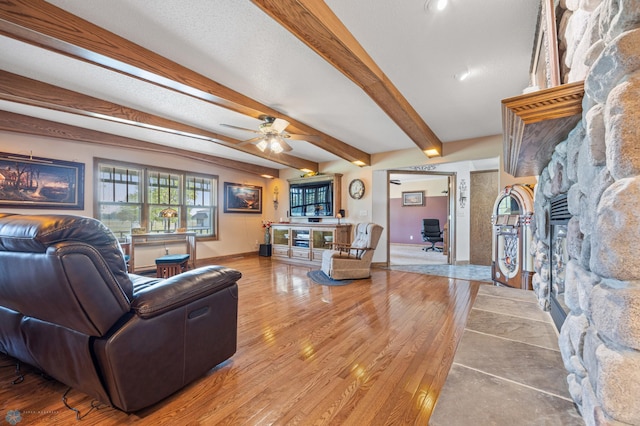 18000 10th St SW, Hawley, MN 56549 - living area with a fireplace, a ceiling fan, baseboards, beamed ceiling, and light wood finished floors