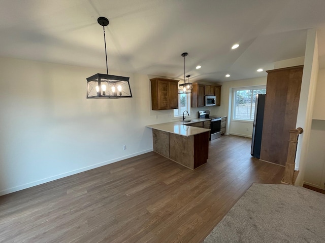 32755 Naples St NE, Cambridge, MN 55008 - kitchen featuring appliances with stainless steel finishes, a peninsula, a sink, dark wood-style flooring, and baseboards