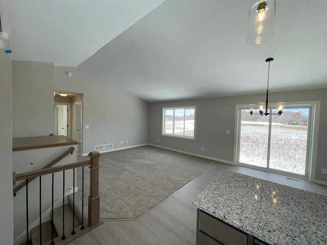 32755 Naples St NE, Cambridge, MN 55008 - unfurnished dining area featuring a chandelier, a textured ceiling, wood finished floors, vaulted ceiling, and baseboards