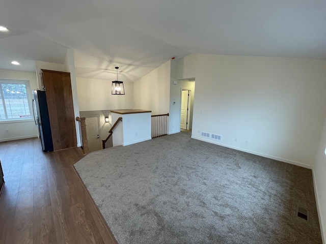 32755 Naples St NE, Cambridge, MN 55008 - unfurnished living room featuring vaulted ceiling, baseboards, and dark wood-type flooring