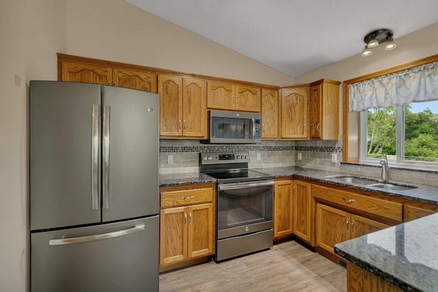 1506 6th Ave N, Sartell, MN 56377 - kitchen with stainless steel appliances, a sink, vaulted ceiling, dark stone countertops, and backsplash
