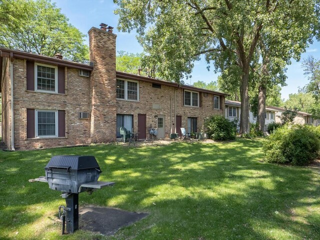 4600 Cedar Lake Rd S Unit 6, Saint Louis Park, MN 55416 - rear view of house with a chimney, a yard, and brick siding
