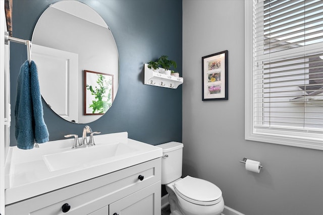 11444 Creekside Ct, Rogers, MN 55311 - half bathroom featuring toilet, vanity, plenty of natural light, and baseboards