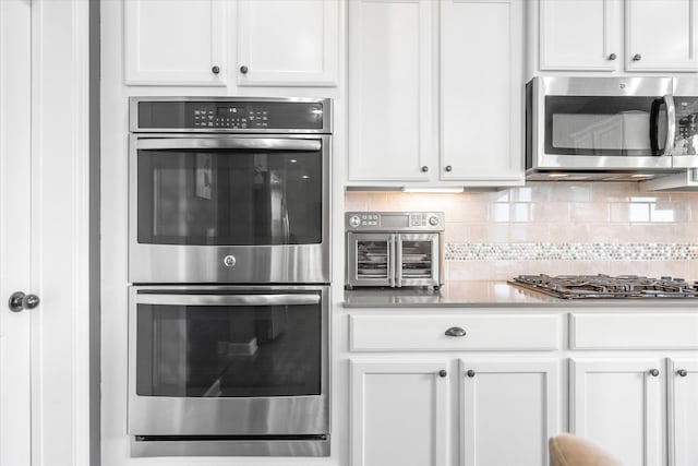 11444 Creekside Ct, Rogers, MN 55311 - kitchen featuring stainless steel appliances, backsplash, white cabinetry, and light countertops