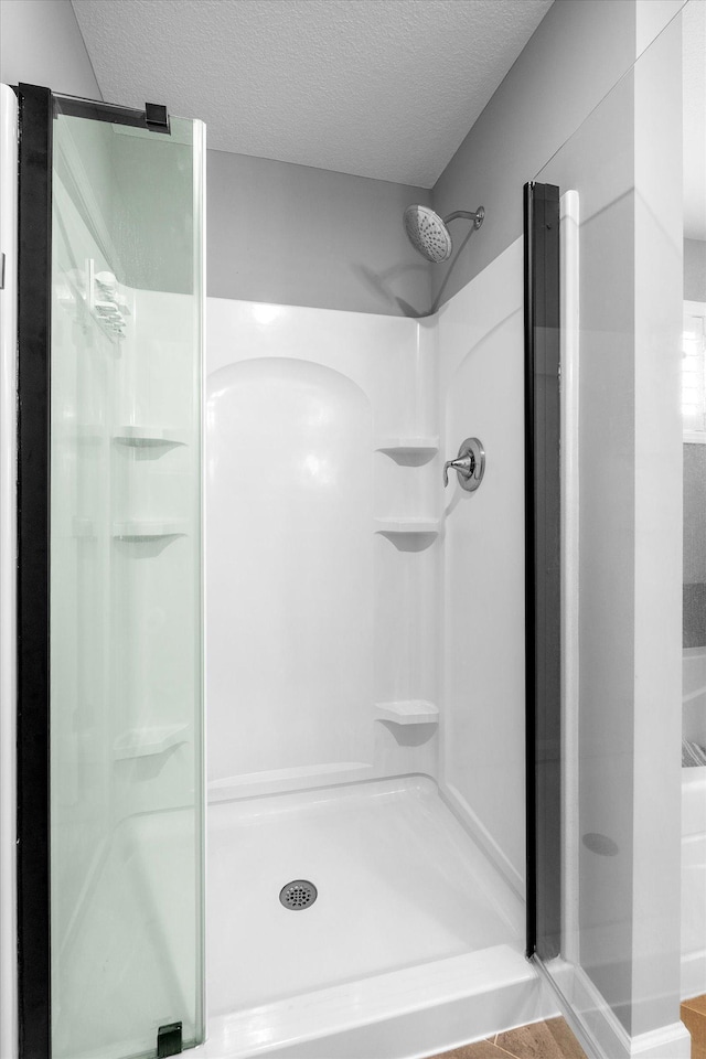 11444 Creekside Ct, Rogers, MN 55311 - bathroom featuring a stall shower and a textured ceiling