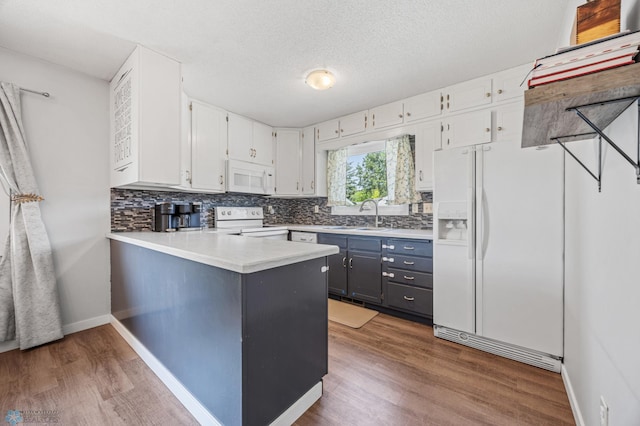 1311 Joseph St, Hawley, MN 56549 - kitchen featuring white appliances, a sink, wood finished floors, and white cabinetry