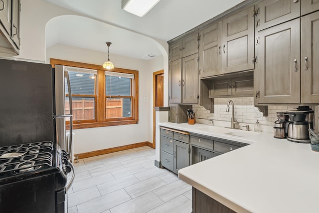 5705 36th Ave S, Minneapolis, MN 55417 - kitchen with black gas range oven, decorative backsplash, light countertops, gray cabinets, and decorative light fixtures