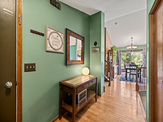 201 3rd St NW, Saint Michael, MN 55376 - hallway featuring a chandelier, a textured ceiling, light wood-style flooring, and lofted ceiling