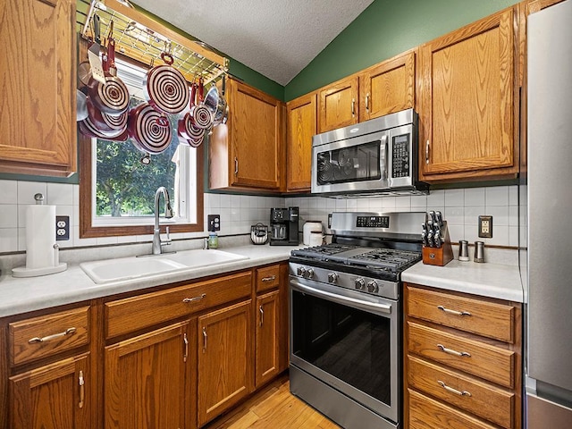 201 3rd St NW, Saint Michael, MN 55376 - kitchen with appliances with stainless steel finishes, light countertops, brown cabinets, decorative backsplash, and lofted ceiling