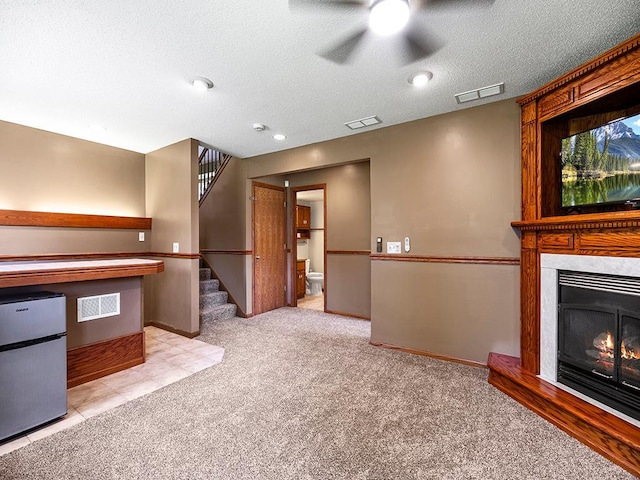 201 3rd St NW, Saint Michael, MN 55376 - unfurnished living room featuring stairway, carpet flooring, a textured ceiling, ceiling fan, and a warm lit fireplace