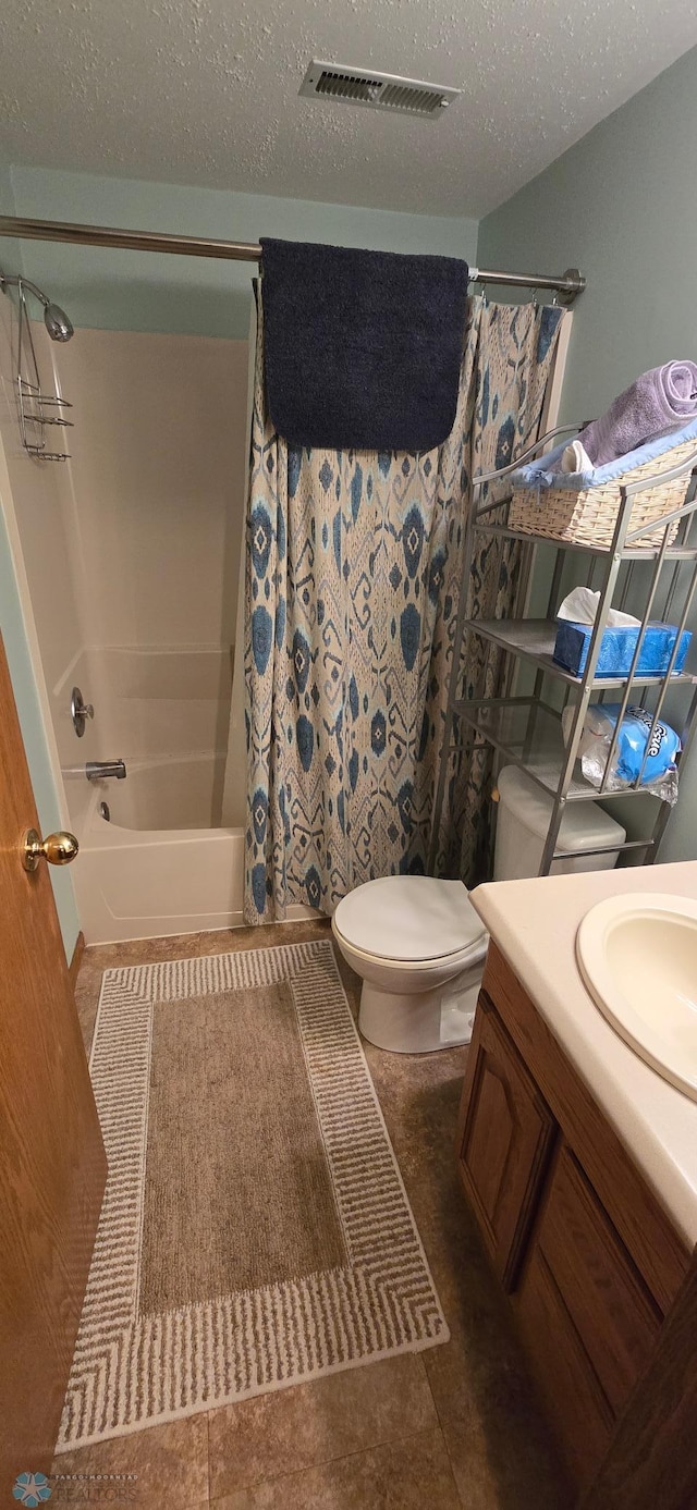 4708 21st St N, Moorhead, MN 56560 - bathroom featuring shower / bath combination with curtain, vanity, toilet, and a textured ceiling