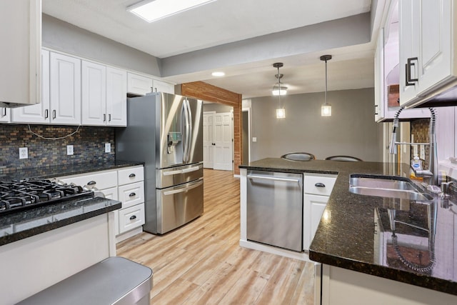 1985 Mabel Ct, Chaska, MN 55318 - kitchen featuring stainless steel appliances, white cabinetry, hanging light fixtures, tasteful backsplash, and light wood-style flooring