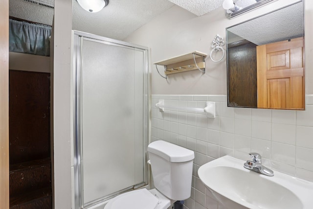 1985 Mabel Ct, Chaska, MN 55318 - bathroom featuring a textured ceiling, a shower stall, and tile walls