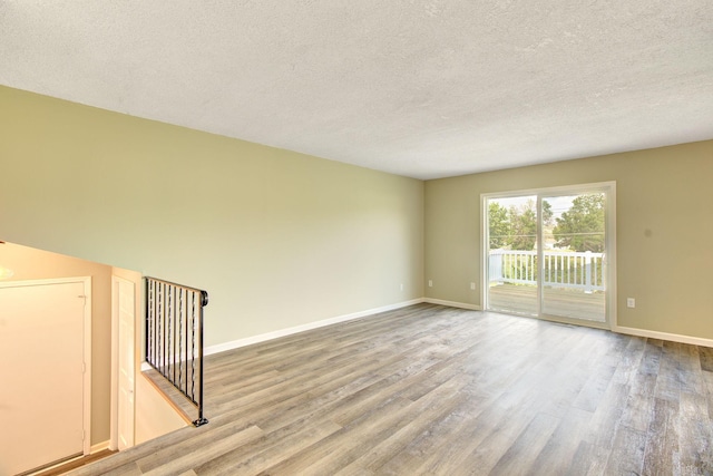 1414 5th Ave SW, Rochester, MN 55902 - unfurnished room featuring wood finished floors, a textured ceiling, and baseboards
