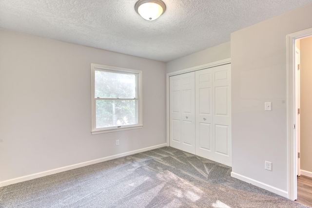 1414 5th Ave SW, Rochester, MN 55902 - unfurnished bedroom featuring a textured ceiling, a closet, dark colored carpet, and baseboards